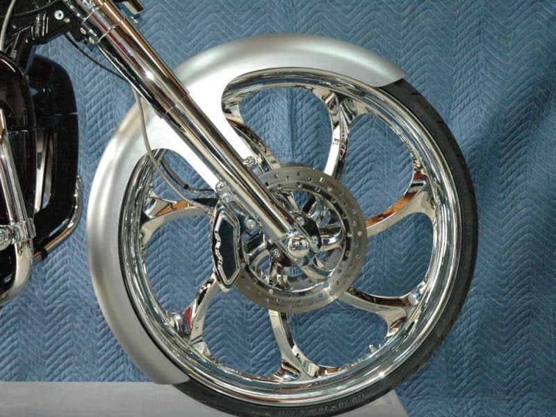 Chrome motorcycle wheel and disc brake close-up, high-performance bike parts.