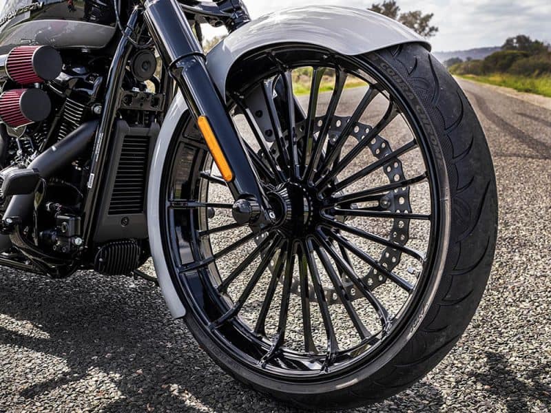 Aerodynamic motorcycle front wheel with custom black alloy rim and disc brake, ideal for Harley Davidson touring bikes.