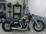 Harley-Davidson motorcycle with flame paint job in workshop setting.