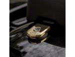Shiny gold motorcycle seat lock with Harley-Davidson logo detail in close-up.