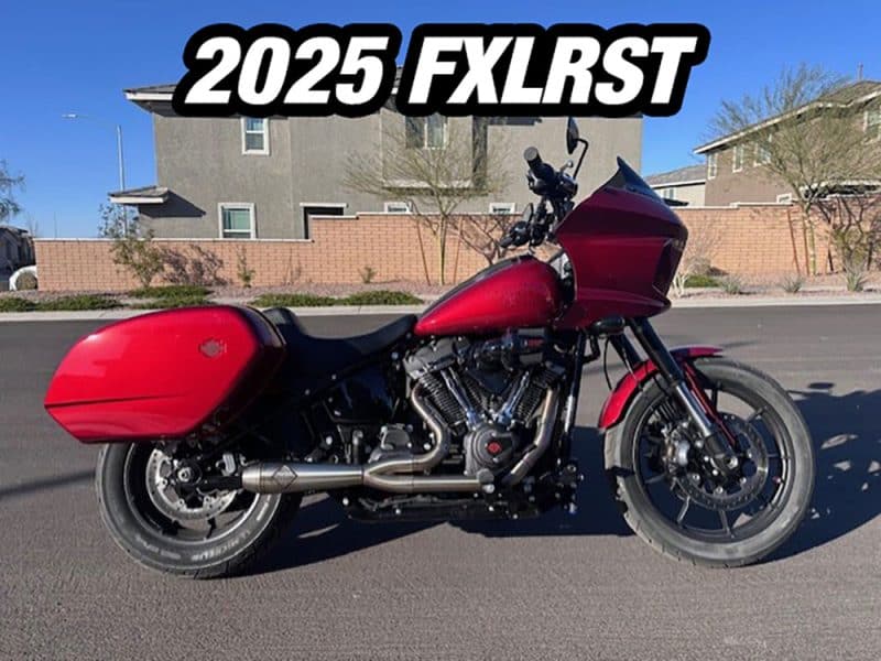 2025 Harley Davidson FLTRXS red touring motorcycle on the road in a suburban area.
