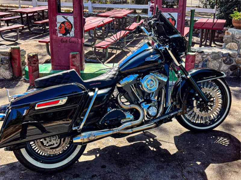Black Harley Davidson motorcycle parked outside Revelry Cycles in Australia.