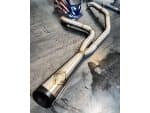 Stainless steel motorcycle exhaust pipe with custom welds and expansion chamber for Harley Davidson bikes.
