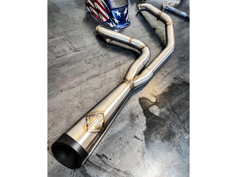 Stainless steel motorcycle exhaust pipe with custom welds and expansion chamber for Harley Davidson bikes.