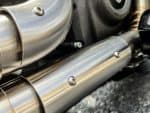 High-quality motorcycle exhaust pipe, close-up of sleek metal design at Revelry Motorcycles.