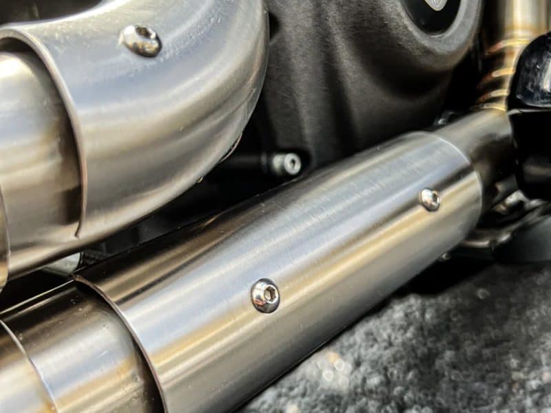 High-quality motorcycle exhaust pipe, close-up of sleek metal design at Revelry Motorcycles.