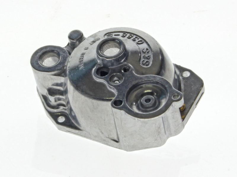 Aluminium motorcycle engine part with engraved serial number and mounting holes.