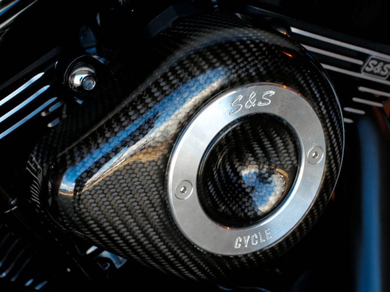 High-performance motorcycle engine with carbon fibre detailing at Revelry Cycles, showcasing premium custom bike parts.