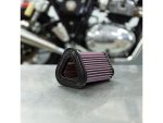 Revelry Motorcycles high-performance air filter on metallic surface with motorcycle engine in background.