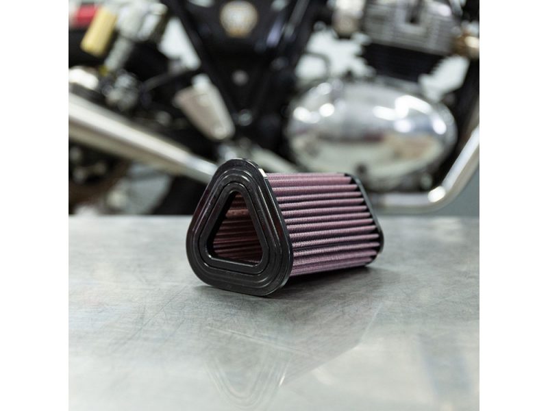 Revelry Motorcycles high-performance air filter on metallic surface with motorcycle engine in background.