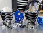 High-performance motorcycle engine components with cylinders, pistons, and blue anodised parts for Revelry Motorcycles.