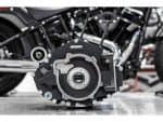High-performance motorcycle engine part on grey surface at Revelry Motorcycles shop.