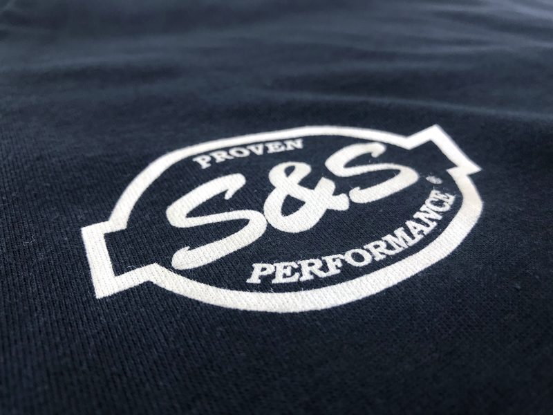 S&S Proven Performance motorcycle logo on dark fabric, close-up shot.