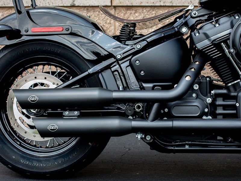 Dark matte motorcycle exhaust and engine close-up, Harley-Davidson style, ideal for motorcycle accessories and customisations.