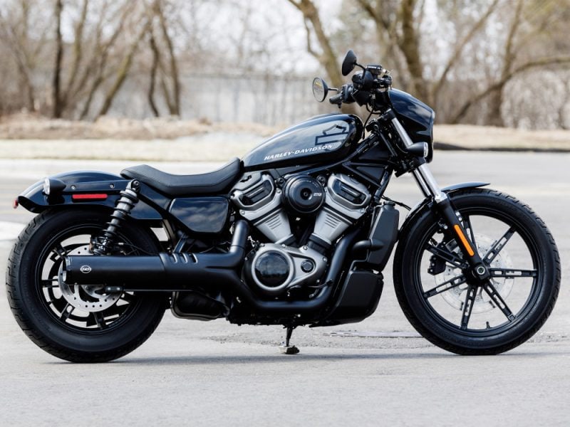 Harley Davidson motorcycle on open road in natural setting.