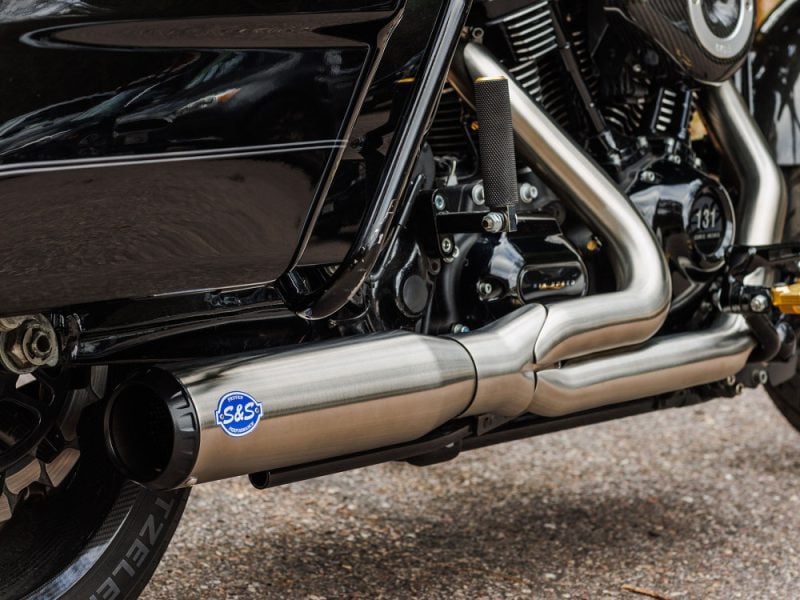 Exhaust system detail of Revelry Motorcycles Harley-Davidson motorcycle, showcasing high-performance S&S exhaust.
