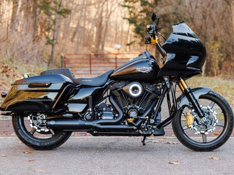 2-into-1 Qualifier Exhaust - Black with Black End Cap. Fits Touring 2017up Harley Davidson touring motorcycle in black, outdoor setting.