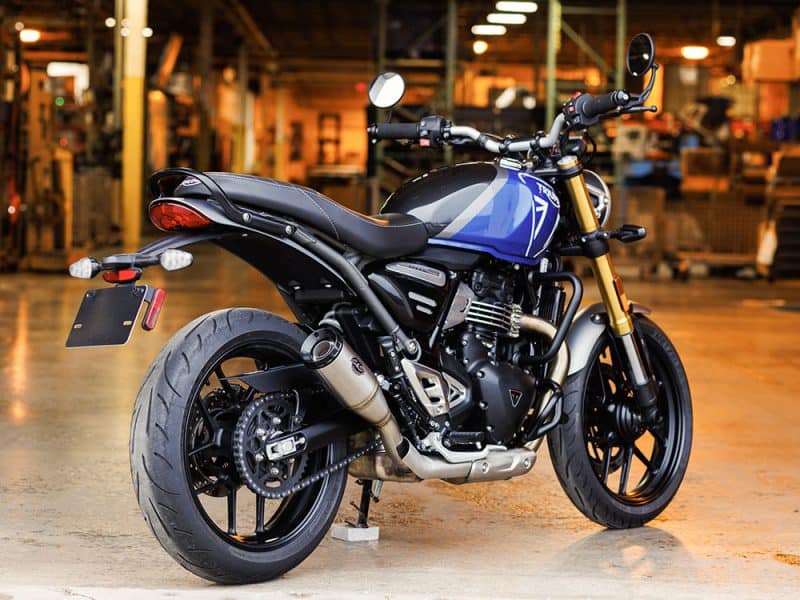 Triumph motorcycle in a warehouse setting, showcasing stylish design and premium components.