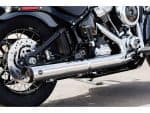 Vented disc brake and chrome exhaust pipe on a Harley-Davidson motorcycle in black and silver.