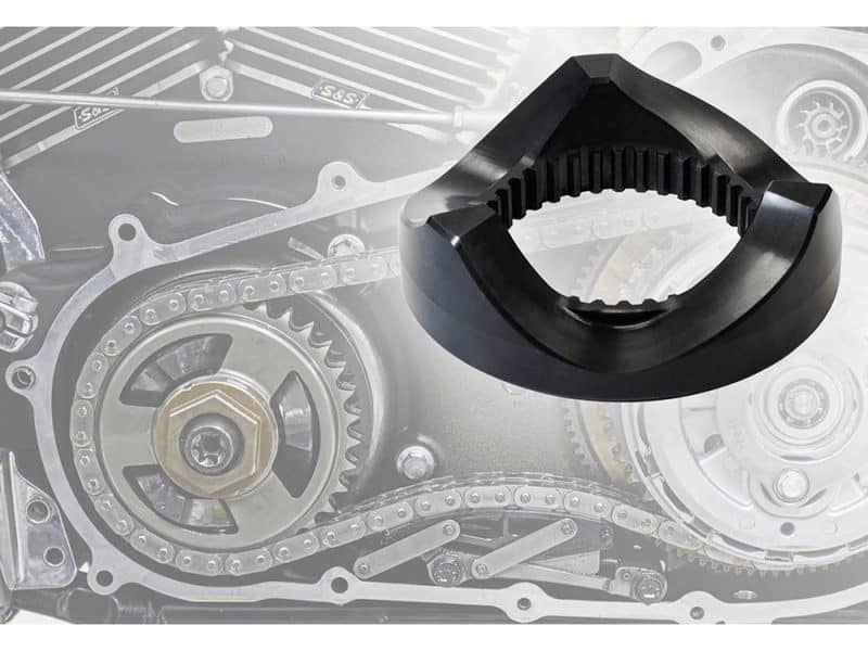 Black motorcycle engine chain guide on engine parts background.