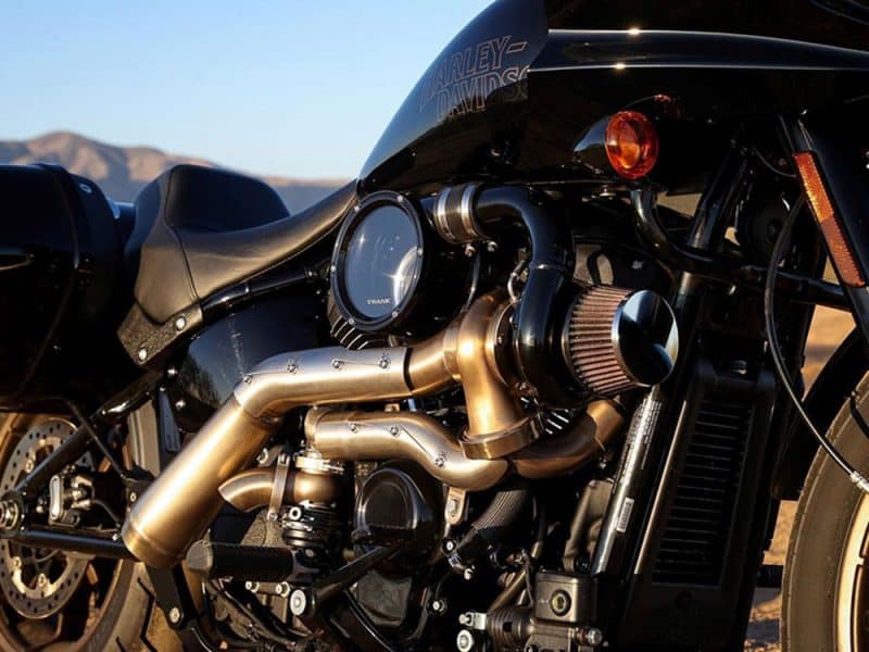 Harley-Davidson motorcycle engine with custom chrome pipes, showcasing high-performance design.