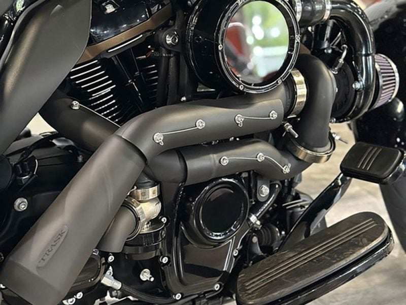 High-performance motorcycle engine with custom matte black exhaust pipes and chrome accents.