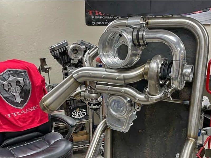 Unfinished motorcycle turbocharger components on workbench in motorcycle workshop.