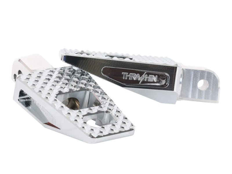 Aluminium motorcycle foot pegs with Traction branding, CNC machined for durability; suitable for Harley and dirt bikes.