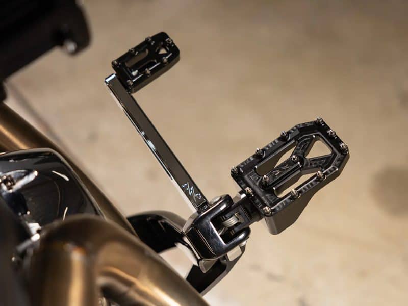 High-performance motorcycle footpeg and brake pedal mounted on a sleek bike frame, ideal for custom motorcycle builds.