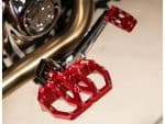 Aluminium motorcycle foot pegs with red anodized finish, designed for durability and style.