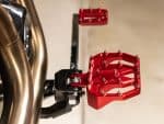 High-performance motorcycle footpeg with custom red finish for Revelry Motorcycles.