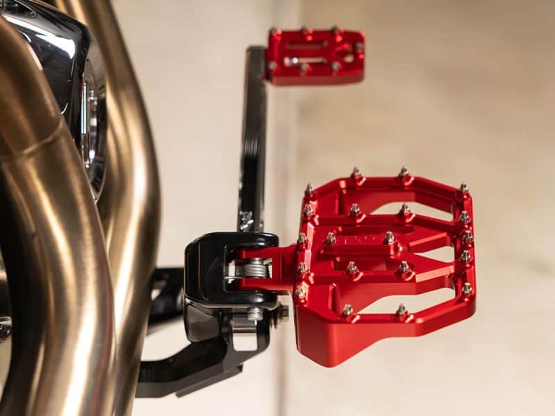 High-performance motorcycle footpeg with custom red finish for Revelry Motorcycles.