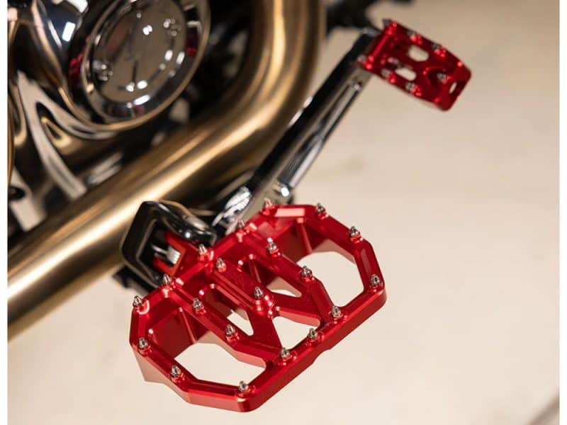 Bright red motorcycle footpeg with CNC-machined aluminium finish, ideal for custom bikes and riding comfort.