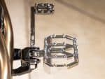 Sleek chrome motorcycle footpegs on Revelry Motorcycles custom bike, showcasing quality and craftsmanship.