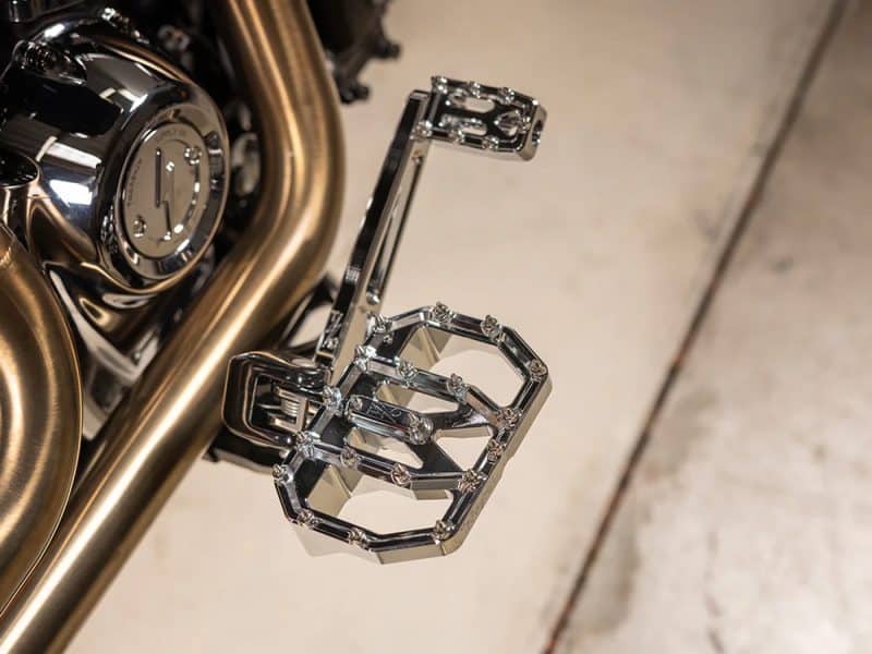 Chrome motorcycle footpegs on Revelry Motorcycles bike, showcasing custom accessories.