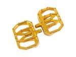 Bright yellow motorcycle foot pegs with metallic accents for Revelry Motorcycles.