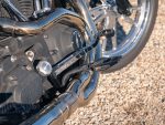 Shiny motorcycle engine with chrome exhaust pipes and textured foot pegs.