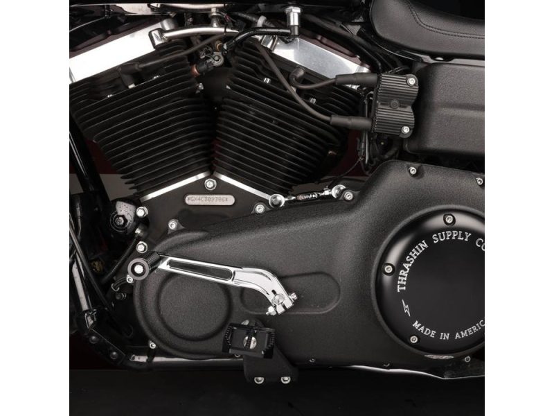 Genuine motorcycle engine close-up with black cooling fins and custom Thrashin Supply cover, ideal for motorcycle parts and accessories.