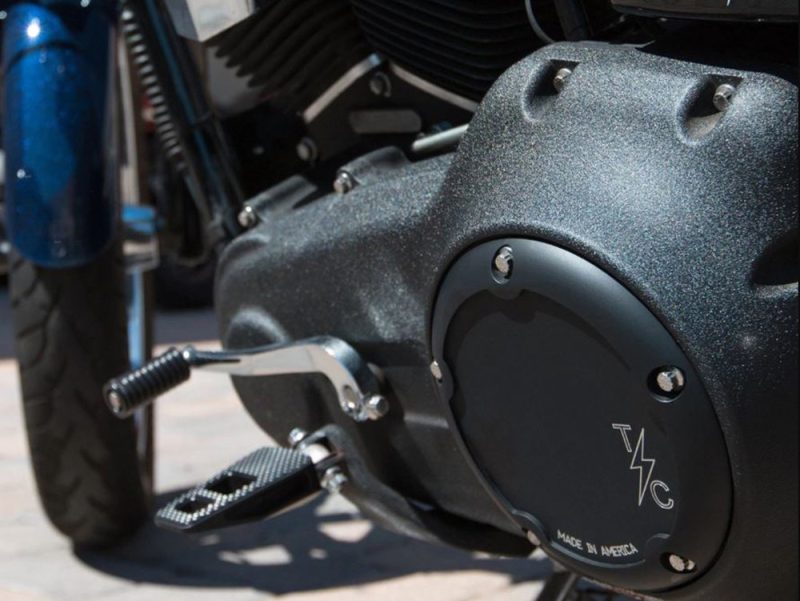 Fast motorcycle engine close-up with black textured covers, showcasing Revelry Cycles' custom American-made parts.