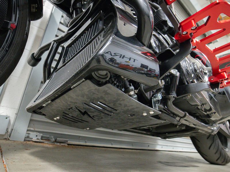High-performance motorcycle undercarriage with customised carbon fibre and aluminium detailing.