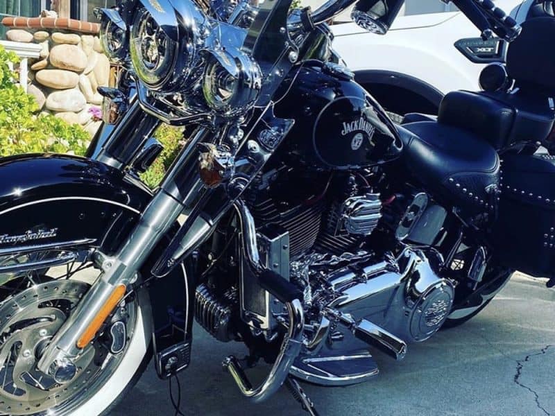Black Harley Davidson motorcycle with chrome accents and Jack Daniel's logo, parked outdoors.