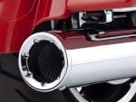Shiny chrome motorcycle exhaust pipe with black carbon fiber inlet, close-up detail.