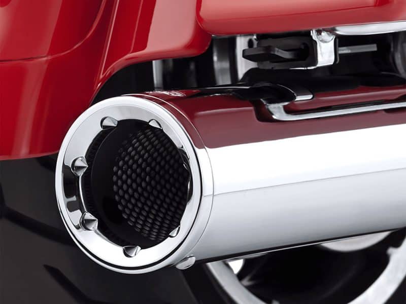 Shiny chrome motorcycle exhaust pipe with black carbon fiber inlet, close-up detail.