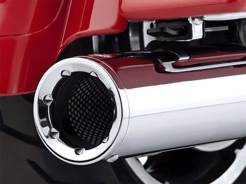 Exhaust pipe of a custom Revelry Motorcycle with polished chrome finish.