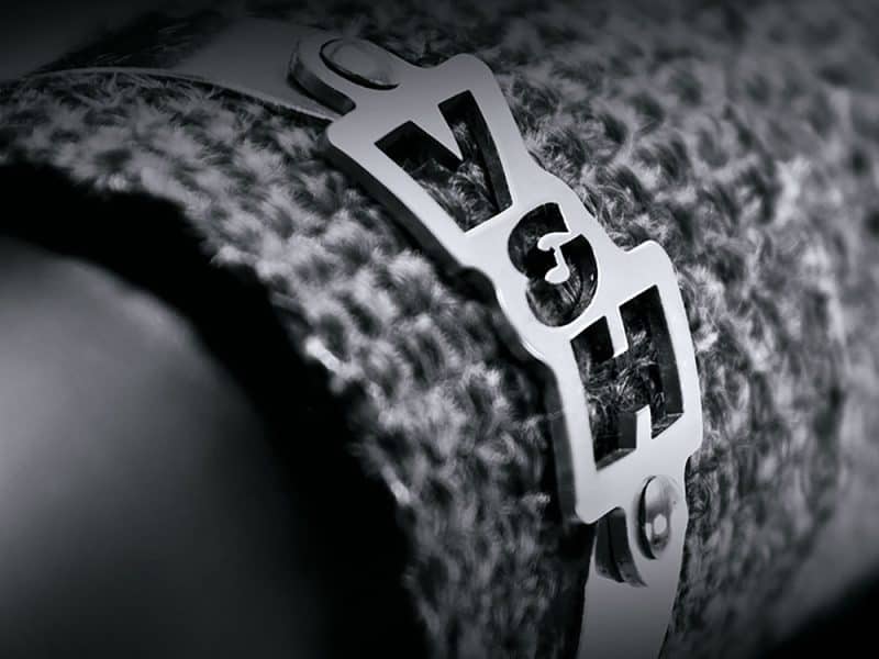 Aluminium Revelry Motorcycle badge on textured fabric close-up.