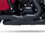 High-performance motorcycle engine close-up, showcasing sleek black exhaust and mechanical details.